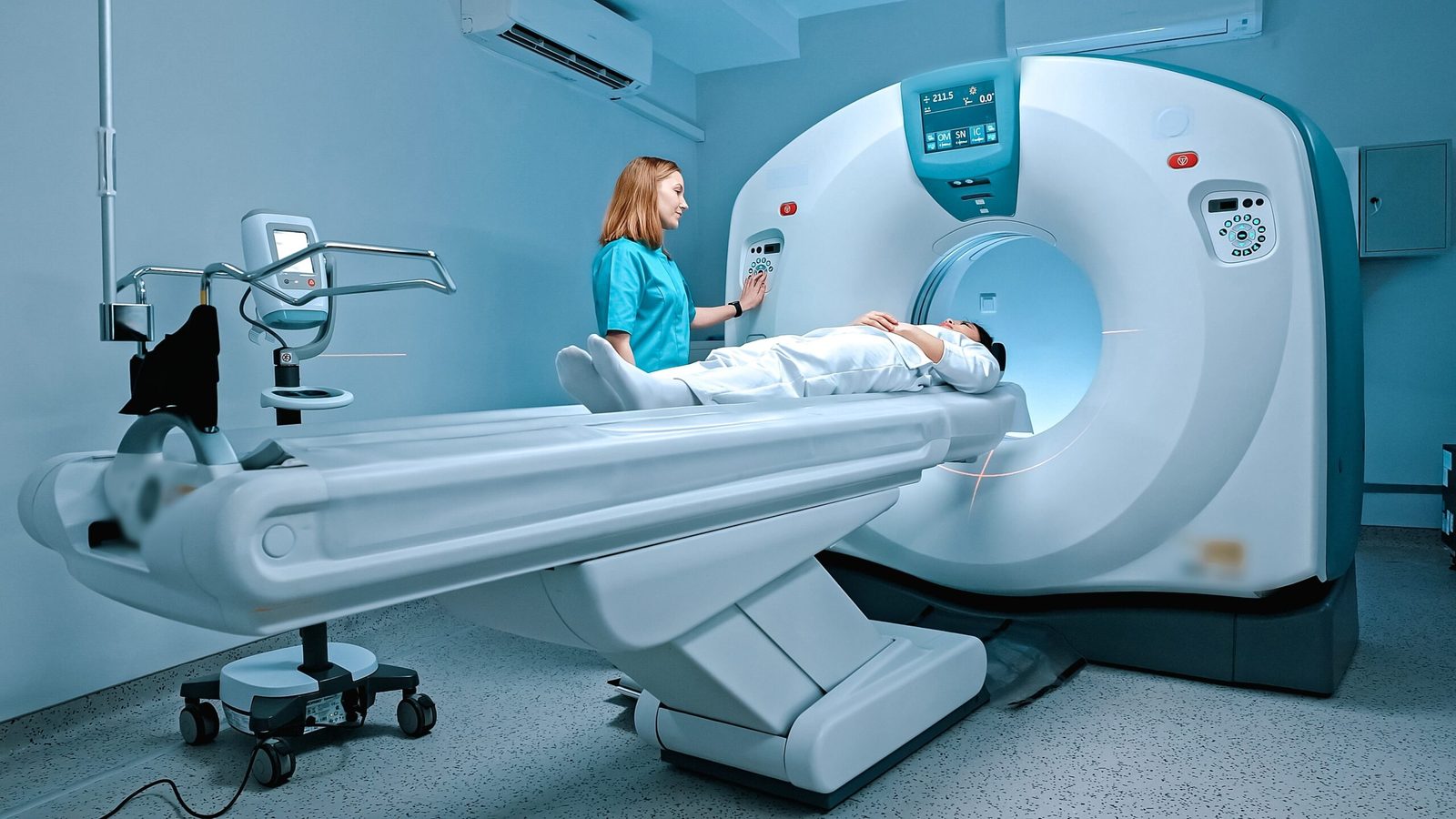 Technician preparing a CT scanner for a patient